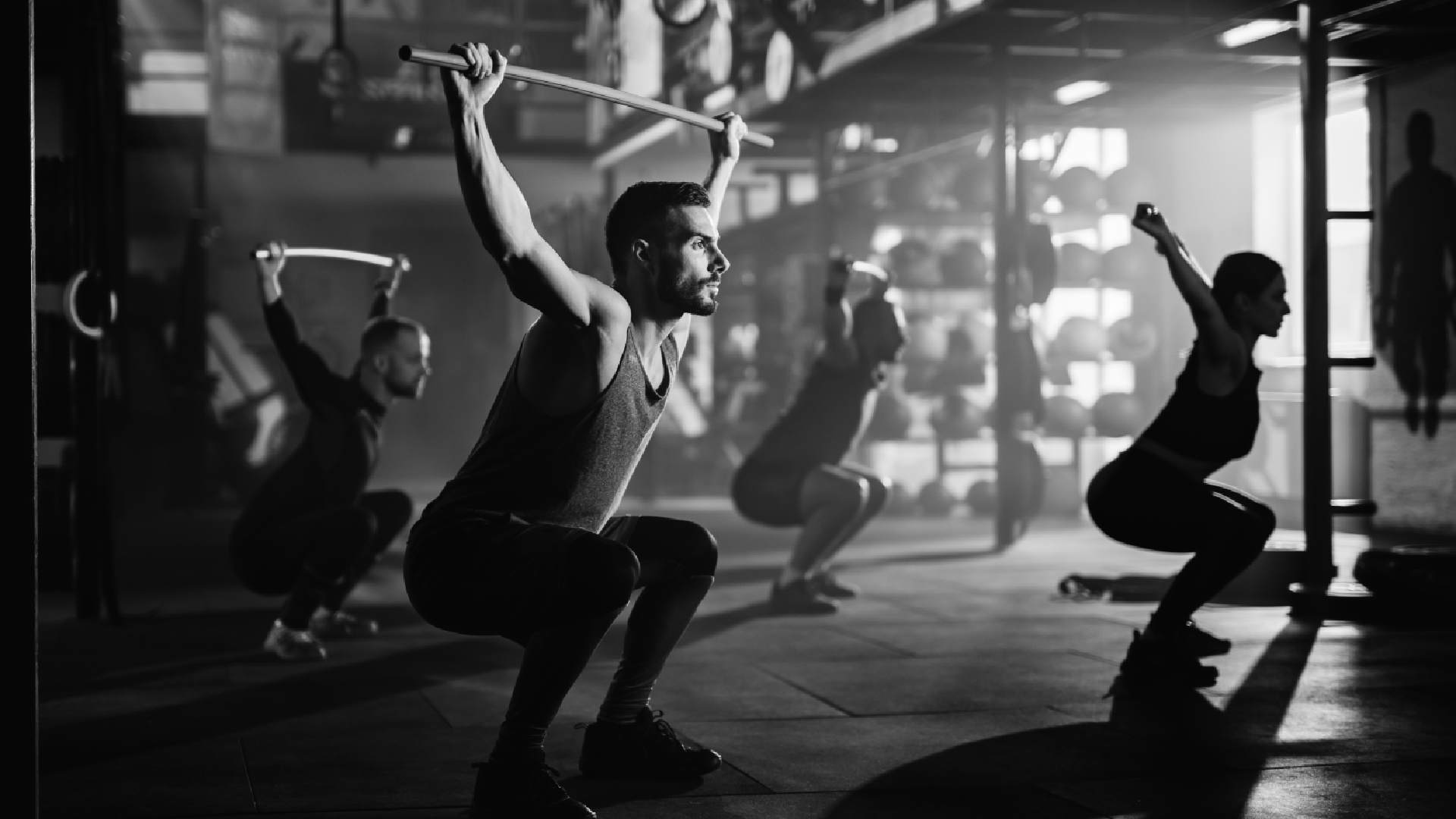 group-athletes-exercising-with-weight-bars-sports-training-gym